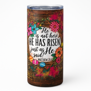 =Tumbler with floral wreath and Easter eggs surrounding the verse “He is not here, He has risen… Matthew 28:6” on a rustic, colorful background